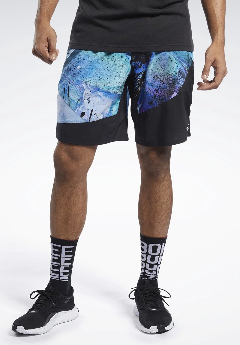Shorts de sport noirs avec motifs abstraits bleus et violets, tissu léger, poches latérales, assortis à des chaussettes noires avec texte blanc.