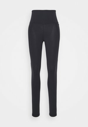 Čierne legíny s vysokým pásom, vyrobené z elastického materiálu. Majú hladkú textúru a priliehajúci strih. Bez viditeľných švov alebo loga.