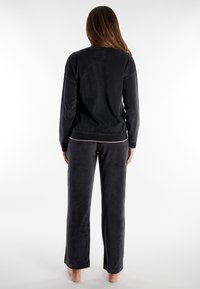 Set di lounge grigio scuro realizzato in morbido tessuto, composto da una maglia a maniche lunghe con scollatura rotonda e pantaloni abbinati dal fit comodo.