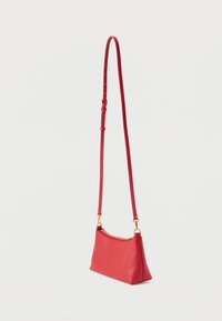 Crvena kožna torba za rame s teksturiranim završetkom, zatvaračem na patent i dugim podesivim remenom. Sadrži ukrase od zlata toniranog metala.