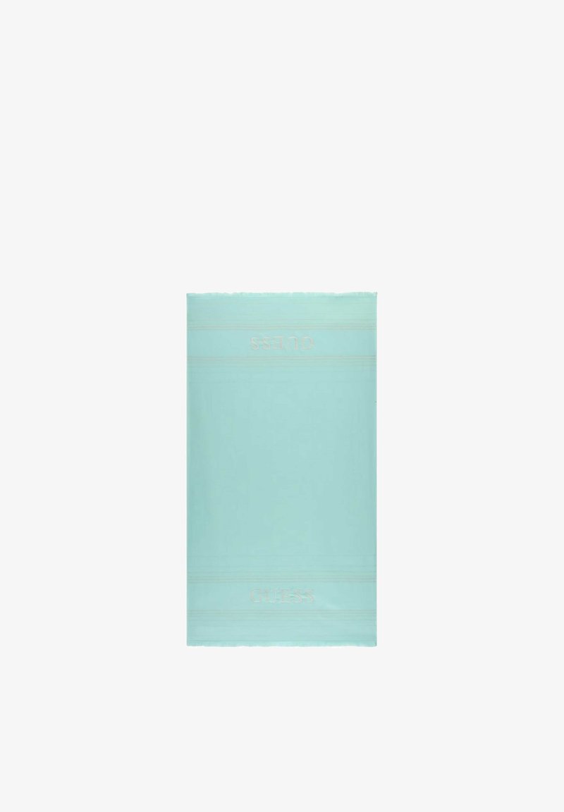 Serviette rectangulaire bleu clair avec le logo "GUESS" brodé en blanc près des bords supérieur et inférieur, affichée à plat.