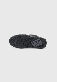 Black footwear sole with textured pattern, featuring the "VANS" logo in grey. Structured grooves for enhanced grip and durability.