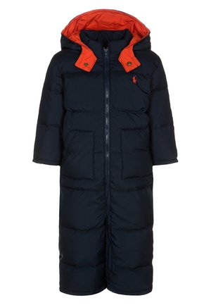 Long manteau d'hiver matelassé bleu marine avec capuche doublée orange, fermeture éclair devant, deux poches et petit logo rouge sur la poitrine.