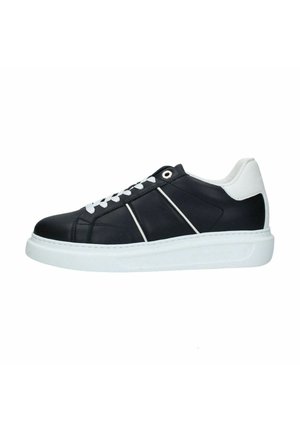 Czarny niski sneaker z białą podeszwą, białymi sznurówkami i białym kołnierzem wokół pięty, z cienkimi białymi paskami ukośnymi po boku.