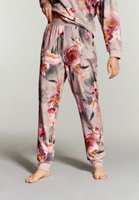 Bloemige pyjamabroek van zacht, roze stof met een slim-fit ontwerp, voorzien van grote bloemenpatronen en een elastische tailleband met zakken.