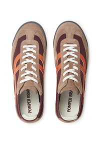 Zapatillas marrones y burdeos que presentan materiales de malla y gamuza, cordones blancos, rayas naranjas y un logo dentro del zapato.