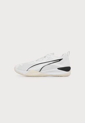 Chaussure de sport basse blanche avec une bande noire incurvée, une semelle beige et un détail noir au talon sur un fond clair uni.