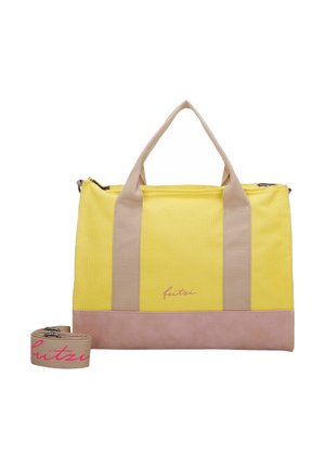 Gelbe und beige rechteckige Handtasche mit zwei beigen Griffen, einem beigen abnehmbaren Riemen mit pinkem Text und einem pinken Bodenpanel.