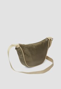 Olijfgroene schoudertas van textuurstof met een beige rand, voorzien van een ritssluiting en een afneembare schouderband.
