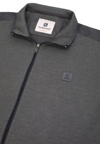 Veste zippée grise texturée avec des accents de col noirs, une écusson logo Gabbiano sur la poitrine et une étiquette Gabbiano à l'intérieur du col.