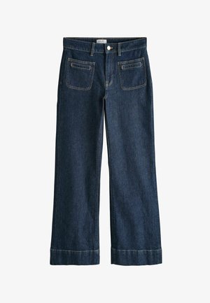 Tmavě modré džíny s širokými nohavicemi, předními náprsními kapsami, poutky na pásek, zapínáním na knoflíky a ohrnutými lemy.