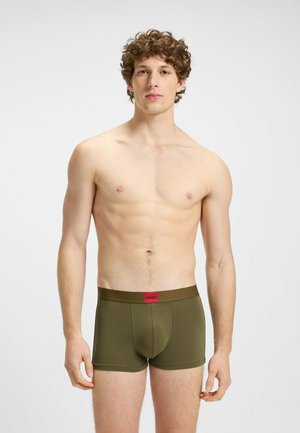 Boxer da uomo verdi con una cintura logo rossa; realizzati in tessuto morbido, presentano una vestibilità attillata e una lunghezza fino a metà coscia.