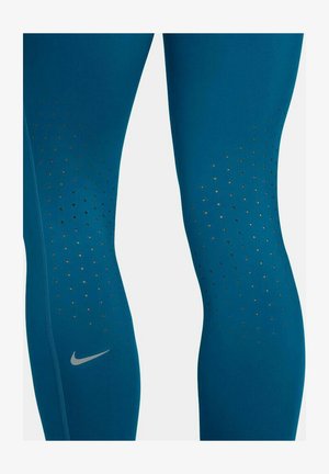 Leggings de Nike en verde azulado con una textura suave que cuentan con agujeros de ventilación y un pequeño logo plateado cerca del tobillo. Diseño ajustado.