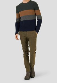 Knitted sweater with horizontal stripes in dark green, brown, gray, and navy. Paired with olive chinos and gray ankle boots.