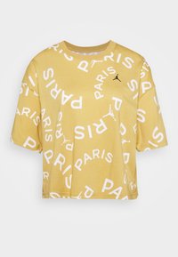 Gul kortärmad t-shirt i bomull med stor vit text "PARIS" och en svart logotyp på bröstet. Korta ärmar och ribbad halsringning.