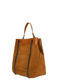 Bruin suède tote bag met leren accenten, voorzien van een bovenhandvat en zwarte kettingbanden. Soepele textuur met een detail van een voorvak.