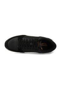 Black sneaker with a smooth leather and suede upper. Features perforated sections, flat laces, and a contrasting white sole. Gold logo on tongue.