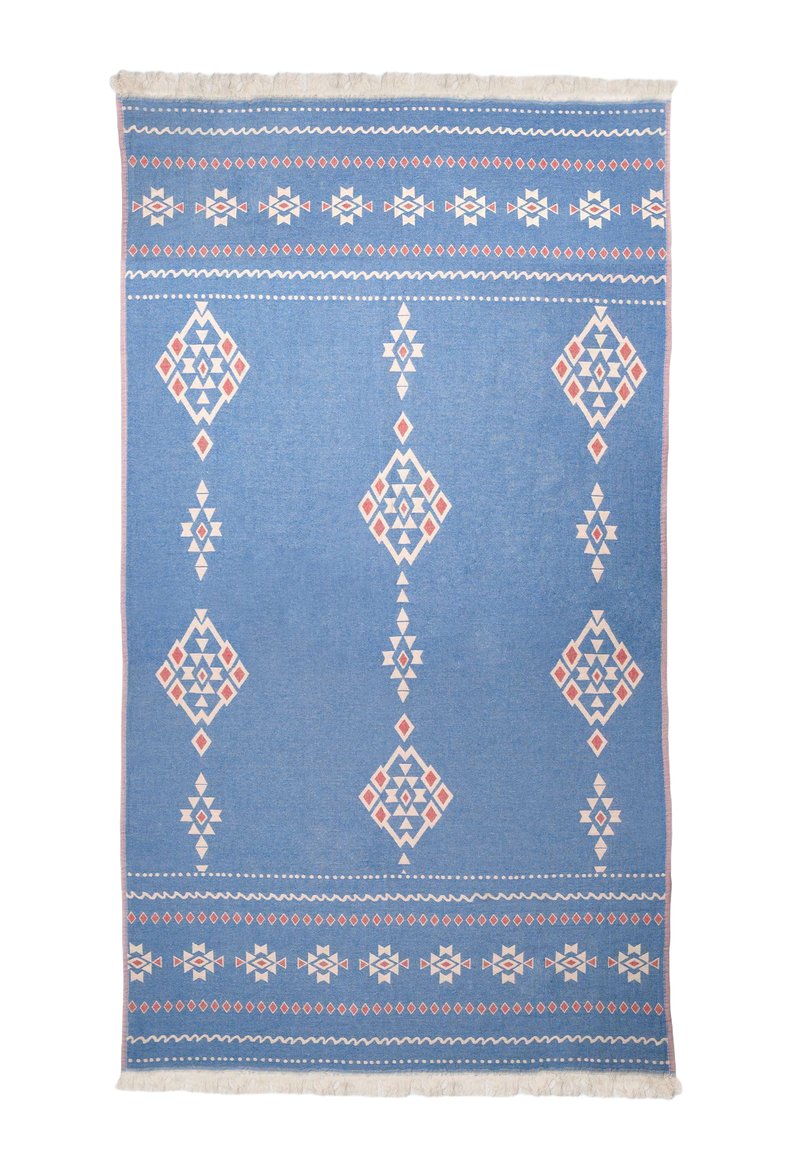 Blue woven rug with diamond patterns in white and red, featuring tassels along one edge. Geometric design and textured finish.
