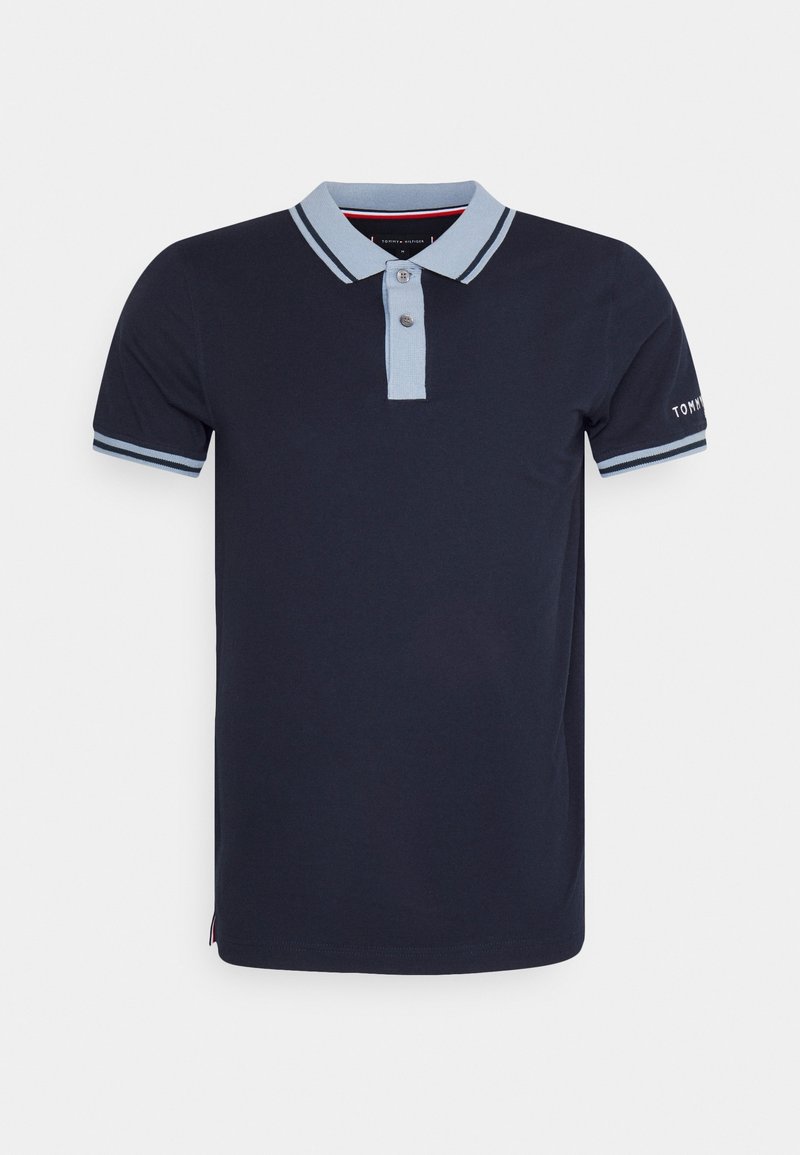 Polo bleu marine en coton avec un col et des accents de manches bleu clair. Il comporte deux boutons et une broderie de marque sur la manche.