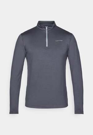 Top a maniche lunghe con zip e collo alto di Calvin Klein in grigio scuro, realizzato in tessuto morbido; presenta un logo minimalista sul lato sinistro del petto.