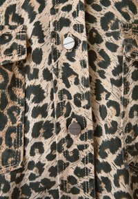 Jacket i leopardprint med en beige baggrund og mørkegrønne pletter, metal trykknapper og to forlommer. Struktureret denimstof.