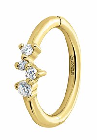 Anillo de oro con tres piedras preciosas redondas y transparentes, engastadas en elegantes piezas de garra, y con una banda lisa y pulida.