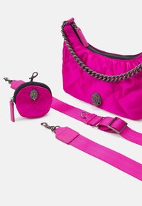 Różowa torebka nylonowa z pikowaniem i łańcuszkowym paskiem, w komplecie z pasującą małą saszetką i materiałowym paskiem. Wyposażona w srebrne akcenty.