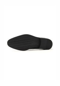 Suela de zapato de goma negra con un diseño plano. Presenta ranuras horizontales para tracción y una forma de punta redondeada. Textura suave en general.