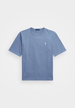 Vaaleansininen lyhythihainen T-paita, jossa on pieni valkoinen Polo Ralph Lauren -logo vasemmassa rinnassa.