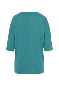 Teal Übergrößen-T-Shirt aus weichem Baumwollmaterial. Mit rundem Halsausschnitt, dreiviertel Ärmeln und geradem Saum. Minimalistisches Design.