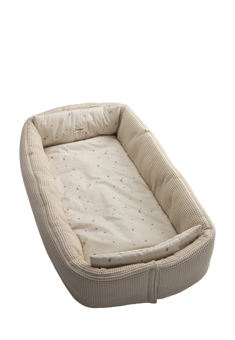 Baby nest with a woven textured exterior in beige, featuring a soft, patterned interior with moon and star designs. Cushioned edges for comfort.
