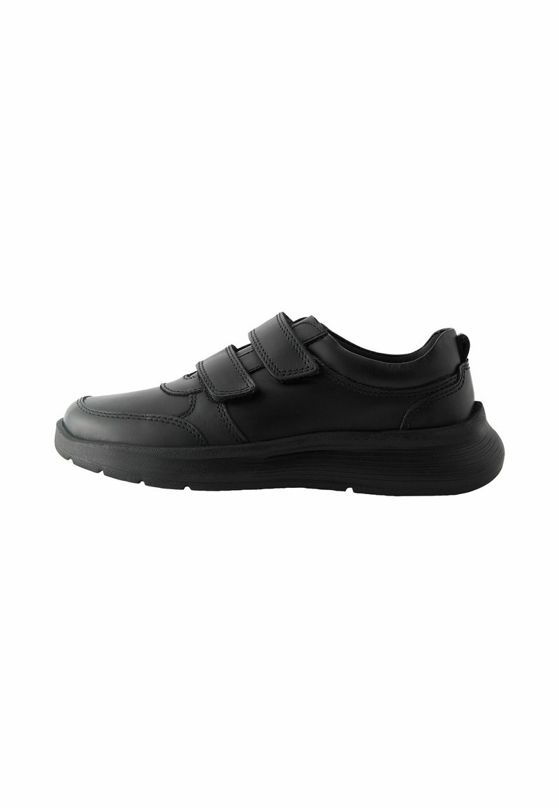 Chaussures de sport noires avec une tige en cuir lisse, dotées de deux sangles Velcro ajustables, d'un bout arrondi et d'une semelle en caoutchouc texturé.