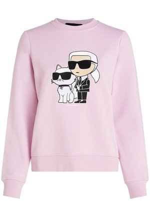Vaaleanpunainen svetari, jossa piirroskuva ihmisestä, jolla on puku ja aurinkolasit, seisomassa valkoisen kissan vieressä, jolla on myös aurinkolasit.