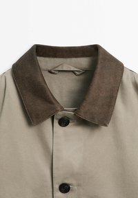 Beige jas met een bruine suède kraag, voorzien van zwarte knopen, een gladde stoftextuur en een klassiek ontwerp met een rechte snit.