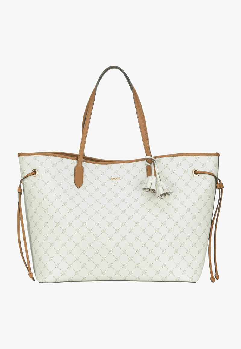 White tote bag with a floral pattern, brown leather straps, and accents. Features two decorative tassels and a spacious interior.