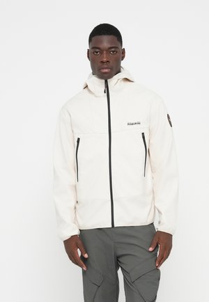 Light beige zip-up jacket with a high collar, two side zip pockets, and black zipper detailing, paired with gray cargo pants.