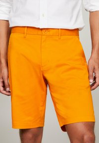 Herreshorts i lys orange bomuldsstof med en glat tekstur, standard livvidde med knaplukning og foldet kanten.
