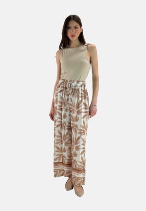 Beige tank top paired with lightweight, cream trousers featuring a brown floral pattern and an elastic waistband with a decorative hem.