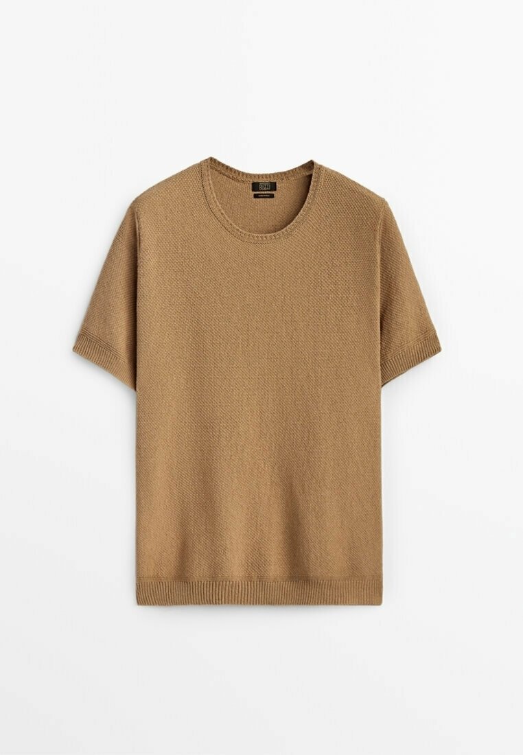 Pull en maille à manches courtes couleur camel avec encolure ronde et poignets côtelés, posé à plat sur un fond blanc.