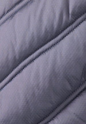 Tessuto grigio trapuntato con una texture liscia. Presenta cuciture diagonali e una leggera lucentezza, che indicano isolamento e durata.