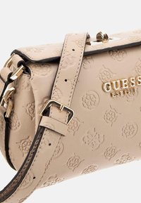 Borsa a tracolla in pelle beige goffrata con logo dorato, dotata di tracolla removibile e dettagli in hardware dorato. Chiusura con particolare elegante.