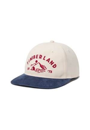 Beige Timberland cap with navy blue corduroy brim, featuring red embroidered mountain logo and "TIMBERLAND EST '73" text on front.