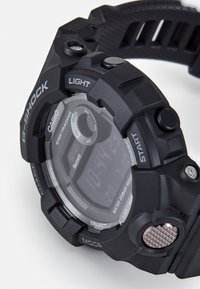 Schwarze G-Shock-Uhr mit Digitalanzeige, strukturiertem Gummiband und mit "START" und "LIGHT" gekennzeichneten Tasten, ausgestattet mit Bluetooth-Konnektivität.