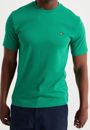 Zielona bawełniana koszulka z okrągłym dekoltem i krótkimi rękawami. Posiada małe żółte logo na lewej stronie klatki piersiowej. Gładka faktura, dopasowany krój.