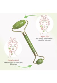 Roulette de visage en jade vert avec une extrémité plus grande pour les joues et le front, et une extrémité plus petite pour le contour des yeux et le nez. Accents en metal doré.
