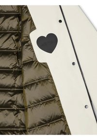 Giacca trapuntata con interno in tessuto verde oliva scuro, esterno crema e un'etichetta a forma di cuore nera con testo in rilievo.