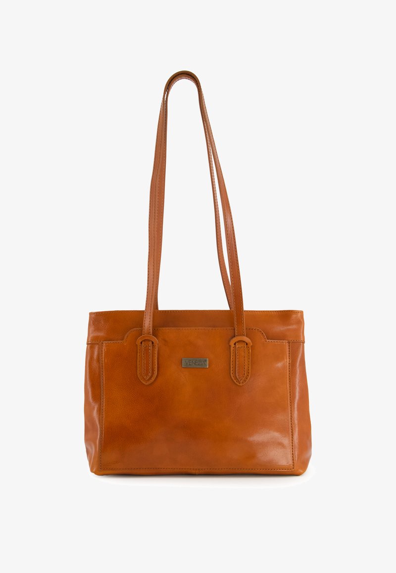 Sac tote en cuir marron avec deux longues poignées, finition polie, détails de couture subtils, et une étiquette de marque métallique sur le devant.