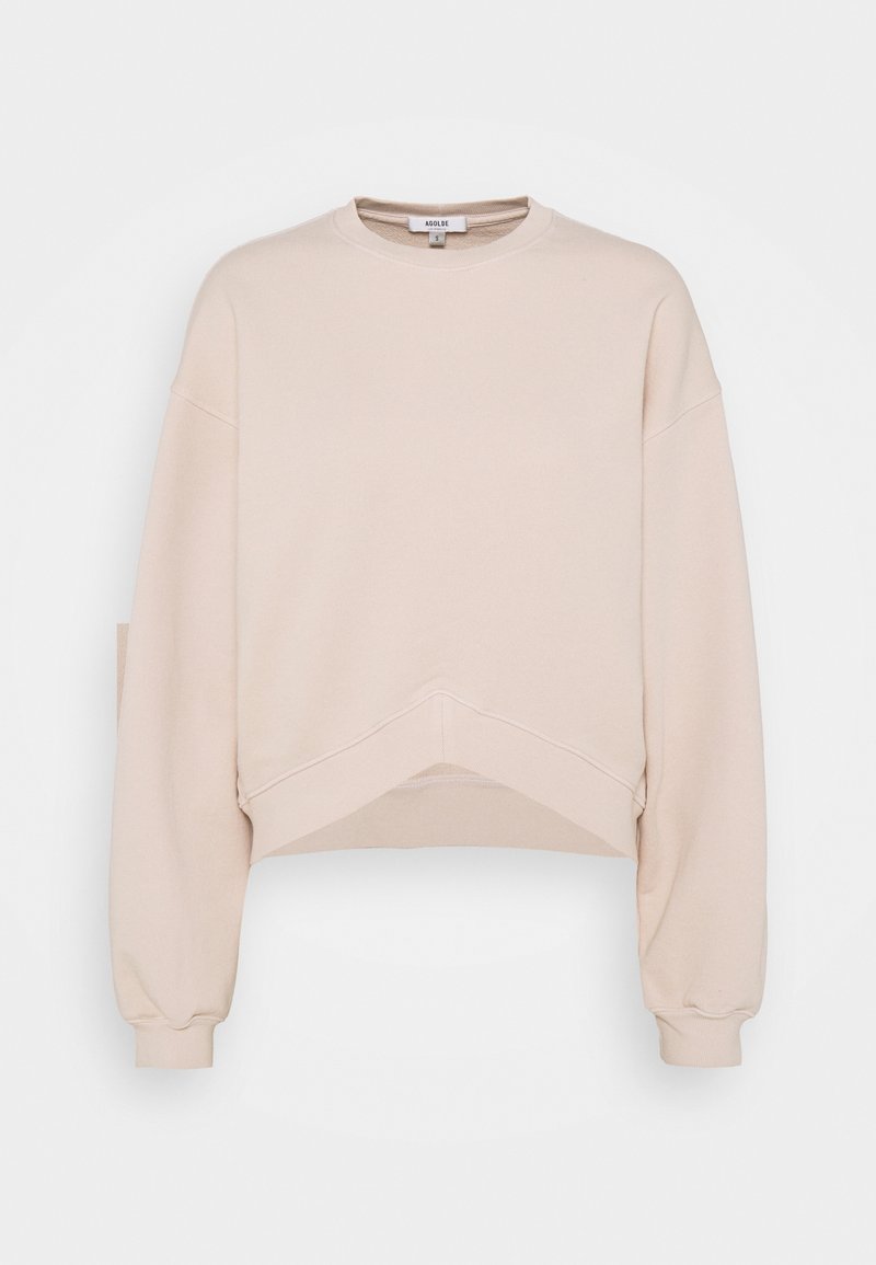 Sudadera recortada en beige claro con mangas largas, cuello redondo y una tela ligeramente texturizada. Presenta un diseño de dobladillo único.