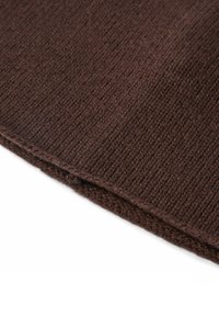Tessuto di maglia marrone con una trama a coste, che mostra un materiale morbido e spesso. Il bordo presenta una cucitura pulita, sottolineando la sua finitura strutturata.