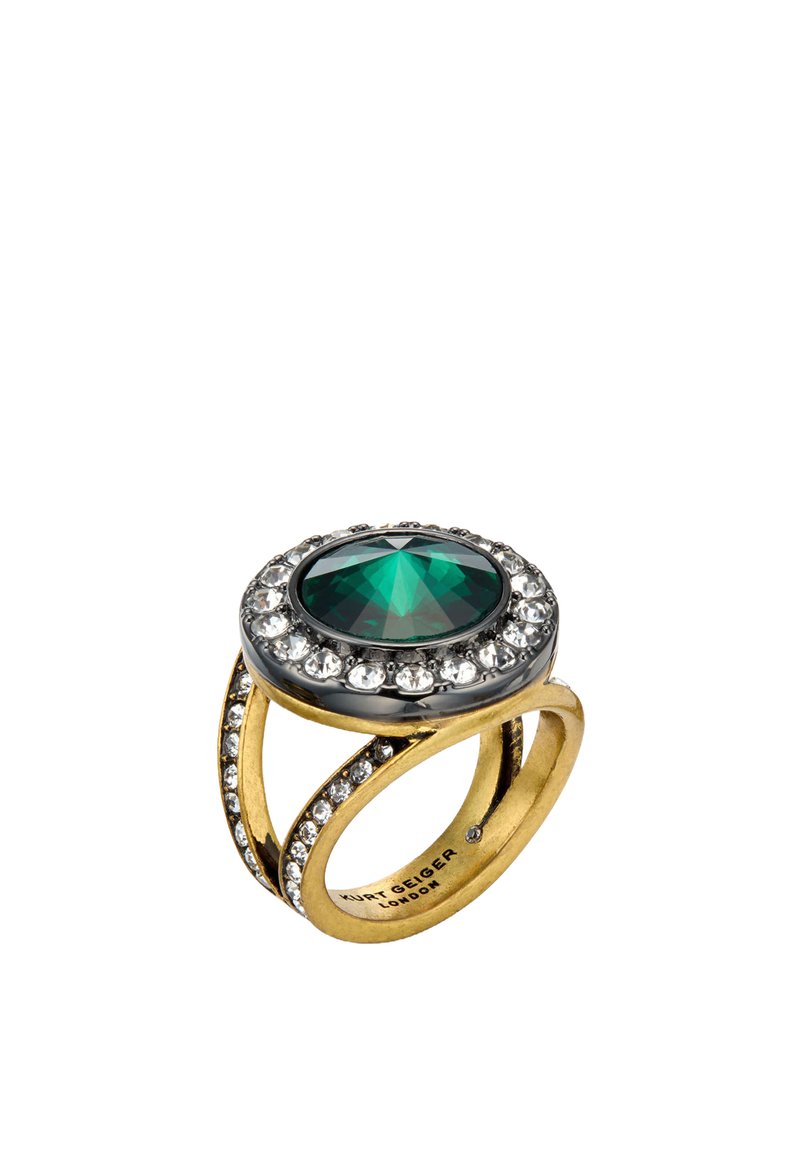Bague dorée avec un centre en pierre précieuse verte ovale, entourée de cristaux clairs, avec un design de bande entrelacée et une finition polie.